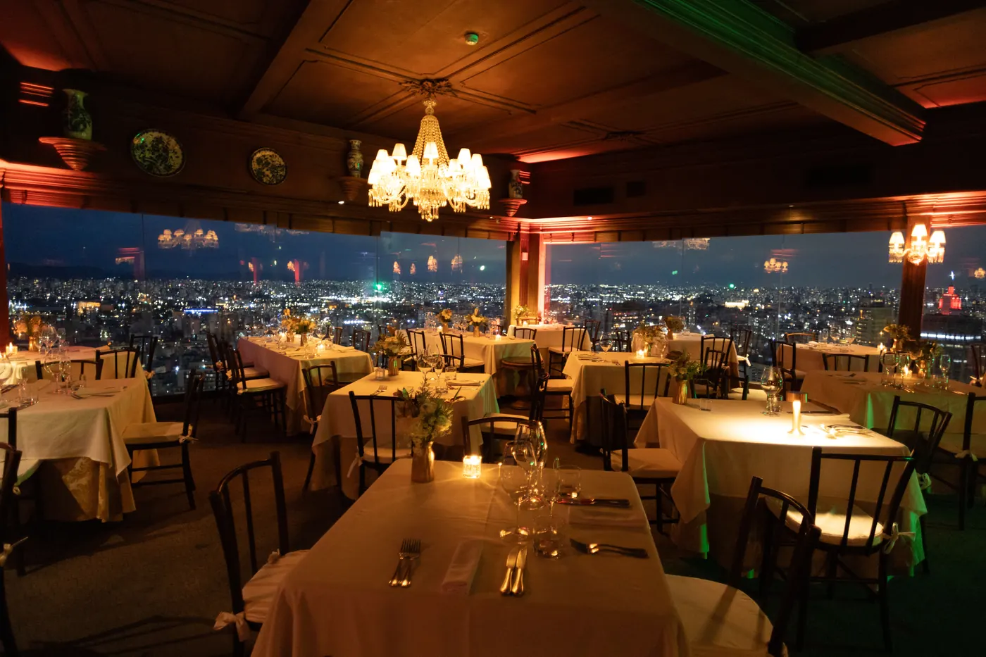Gedeckte Tische im Speisesaal des Terraço Itália am Abend, unter dem Kronleuchter, hinter den Fenstern die Lichter von São Paulo