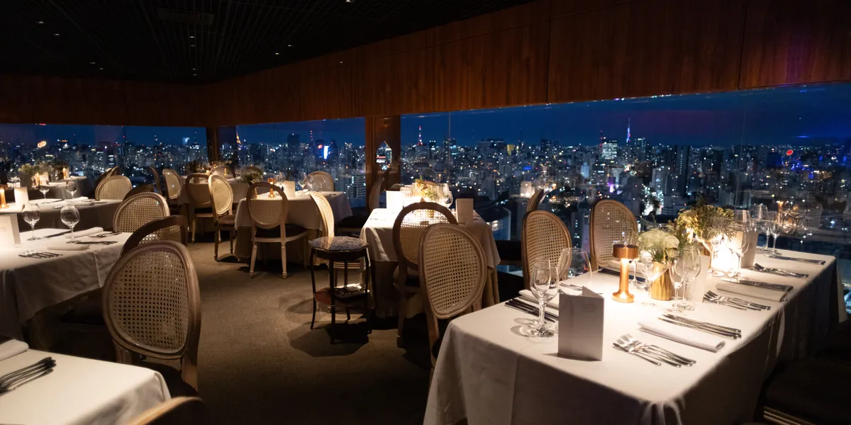 Die Sala Panorama am Abend, mit gedeckten Tischen und den Lichtern von São Paulo hinter den Fenstern