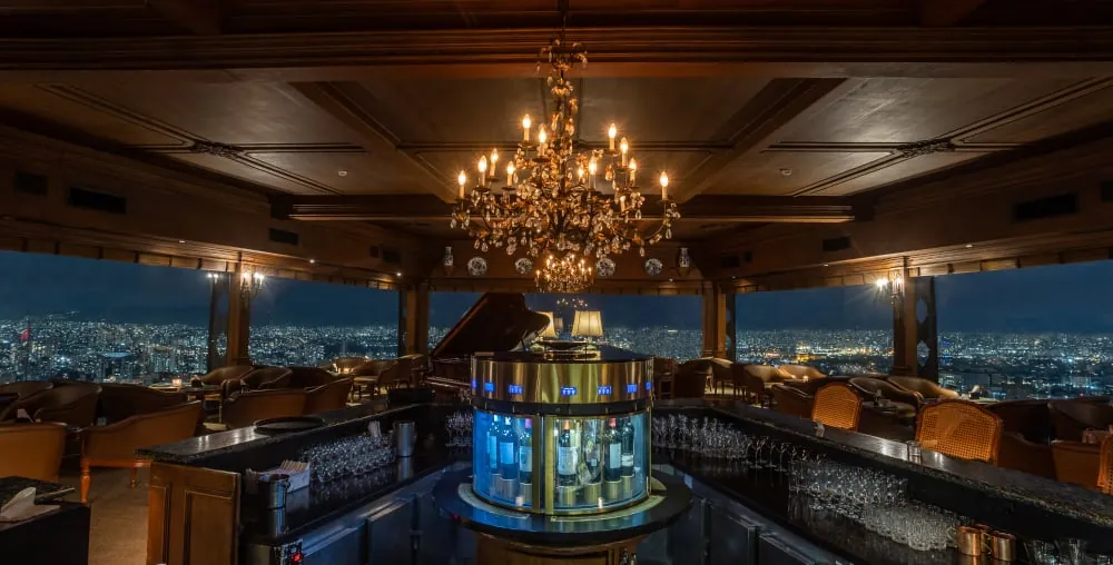 Die Piano Bar am Abend, der Kristallleuchter über der Theke und dahinter die Stadt